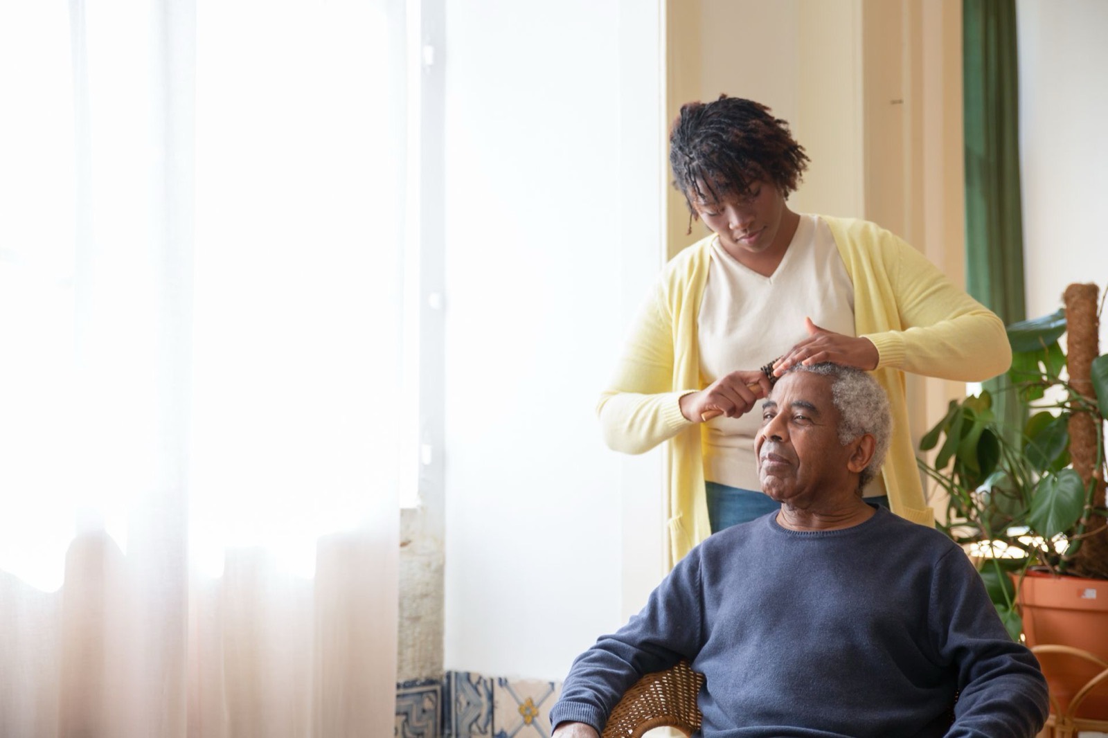 An Ally In-Care caregiver gently helping a senior gentleman with grooming at home
